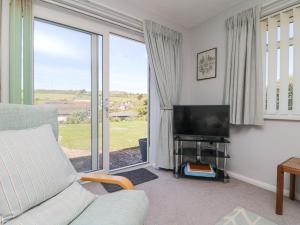 un salon avec un canapé et une télévision dans l'établissement Bre An Mor, à Germoe