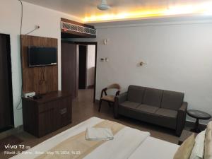 uma sala de estar com um sofá e uma televisão em Hotel Destiny em Patna