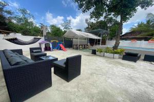 a patio with couches and a hammock and a playground at Asiah's Villa near City center in Dauis