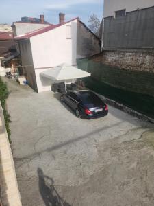 un coche negro aparcado bajo un paraguas blanco en Csikos Apartment en Cluj-Napoca