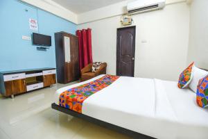 a bedroom with a bed and a flat screen tv at FabExpress Shri Krishna in Pune