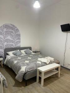 a bedroom with a bed and a table and a lamp at Aria di sale in Trapani