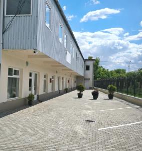 a building with potted plants in a courtyard at Adriana Touristik Hostel 3 Stele Arad in Arad
