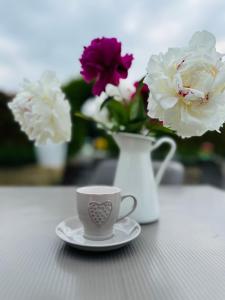 een koffiekopje en een vaas met bloemen op een tafel bij Holiday Home Sovenigo in Puegnago