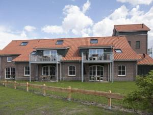 a large brick house with an orange roof at Old fire department ierra del Fuego No 8 OR in Langeoog