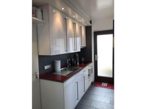 een keuken met witte kasten en een rood aanrecht bij Haas Comfortable holiday residence in Wangerooge