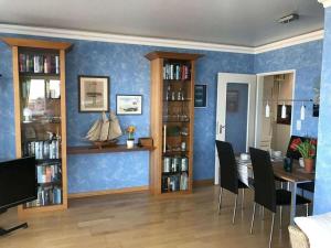 een eetkamer met blauwe muren en een tafel en stoelen bij Haas Comfortable holiday residence in Wangerooge