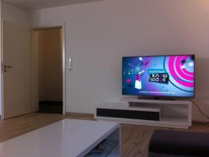 ein Wohnzimmer mit einem Flachbild-TV auf einem Tisch in der Unterkunft New building, first occupancy, Niendorf enclosure in Hamburg