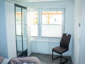 um quarto com uma cadeira e uma janela em Attractive bungalow with roofed terrace em Blankenburg