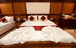 a bedroom with a large bed with two pillows at Holiday Valley Hotels And Resorts in Denkanikottai