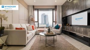 ein Wohnzimmer mit einem Sofa und einem TV in der Unterkunft Wyndham Suites KLCC in Kuala Lumpur