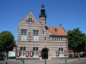 un grand bâtiment avec une tour au sommet dans l'établissement Huijsmans Verhuur Type de Luxe Plus Mosselbank, à Ouddorp