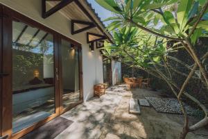un porche de una casa con una palmera en BuBu Villa, en Islas Perhentian