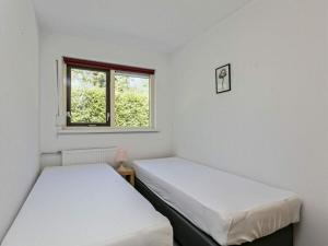 two beds in a small room with a window at Huijsmans Verhuur Type C Comfort Prinsenhof 68 in Ouddorp