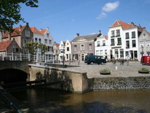 a group of houses and a river in a town at Huijsmans Verhuur Type de Luxe Haringvliet 28 in Ouddorp