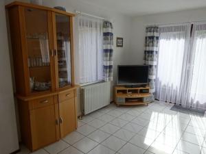a living room with a tv and a cabinet at Huijsmans Verhuur Type de Luxe Haringvliet 28 in Ouddorp