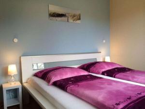 um quarto com uma cama grande e lençóis roxos em Boddensurfer 2a Comfortable holiday residence em Pruchten