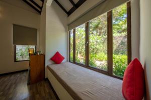 プルフンティアン島にあるブブ ヴィラの赤い枕付きの大きな窓が備わる客室です。