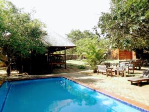 a swimming pool with a picnic table and a pavilion at Utshwayelo Kosi Bay Mouth Lodge & Camp in Manguzi