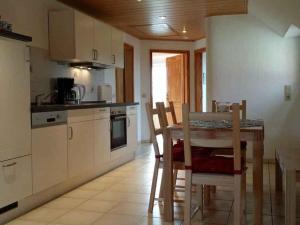 una cucina con tavolo e sedie in una stanza di Friesenblick Comfortable holiday residence a Buttforde