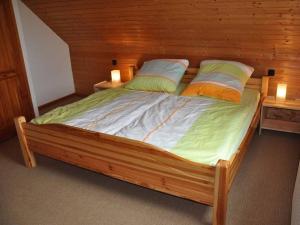un letto in legno in una camera con 2 lampade di Friesenblick Comfortable holiday residence a Buttforde