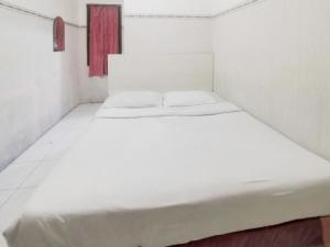 Postel nebo postele na pokoji v ubytování Kartini Residence RedPartner
