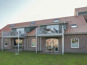 a brick building with balconies and tables and chairs at Old fire department Feuerperle No 4HR in Langeoog