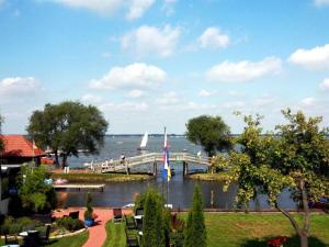 a bridge over the water with a sail boat on it at Lüerßen directly by the sea apartment 7 in Steinhude +16 photos
