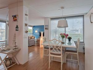 Un comedor y una sala de estar con mesa y sillas. en Holiday home Huijsmansverhuur, en Ouddorp
