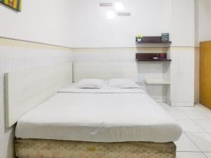 Postel nebo postele na pokoji v ubytování Kartini Residence RedPartner