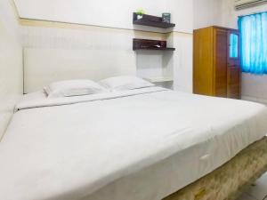 Postel nebo postele na pokoji v ubytování Kartini Residence RedPartner