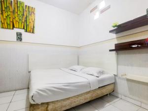 Postel nebo postele na pokoji v ubytování Kartini Residence RedPartner