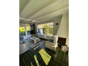 una sala de estar con un sofá y una silla en Huijsmans Verhuur Type C Comfort Plus, en Ouddorp 13 fotos más