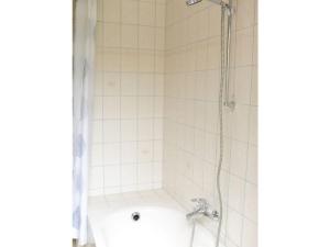 a bathroom with a shower with a white tub at Huijsmansverhuur Type Premium de Luxe in Ouddorp +12 photos