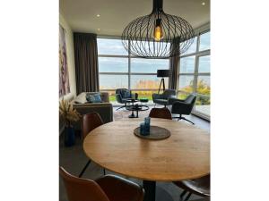 een woonkamer met een tafel en stoelen bij Chalet IJsselmeerstrand First row in Enkhuizen