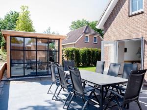 a table and chairs in front of a house at Huijsmansverhuur Type Premium de Mosselbank 115 in Ouddorp