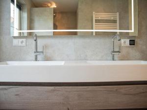 a bathroom with two sinks and a large mirror at Huijsmansverhuur Type Premium de Mosselbank 115 in Ouddorp +28 photos