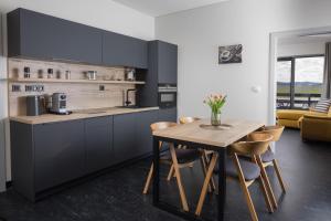 a kitchen with a wooden table and a dining room at Apartmány Hangár Strakonice in Strakonice