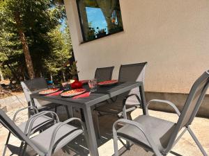 a black table and chairs on a patio at Cabana Ruku in Muntele Băişorii