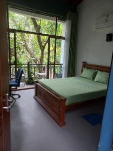 a bedroom with a bed and a large window at Gampaha Heritage in Gampaha