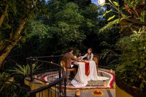 een bruid en bruidegom die samen aan een tafel zitten bij The Sankara Suites and Villas by Pramana in Ubud