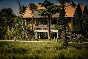 a house with a balcony and a tree at Zannier Hotels Phum Baitang in Siem Reap