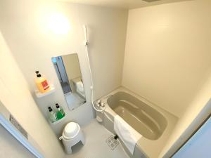 a small bathroom with a tub and a toilet at GuestHouseえにし in Nishi-kujō-Toriiguchichō +69 photos