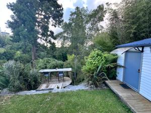 a small blue house with a wooden deck at Green Valley Cabin in Hamilton