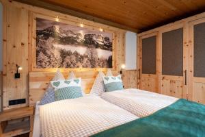 um quarto com duas camas e uma foto na parede em Landhaus Horngacher em Ellmau