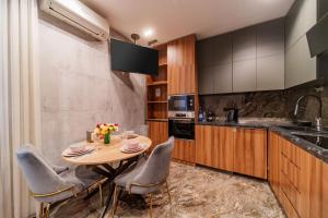 eine Küche mit einem Tisch, Stühlen und einem Waschbecken in der Unterkunft Arch Apart Hotel in Yerevan