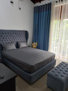 een slaapkamer met een groot bed en blauwe gordijnen bij Gampaha Heritage in Gampaha