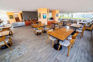 an empty restaurant with wooden tables and chairs at Bartu Otel in Çeşme