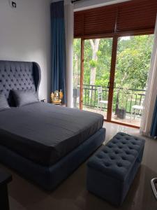 a bedroom with a large bed and a large window at Gampaha Heritage in Gampaha