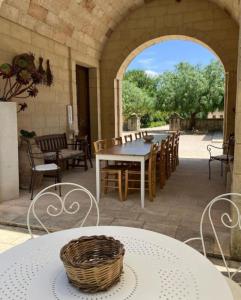 an outdoor patio with a table and chairs at Masseria Sucéa in Martano
